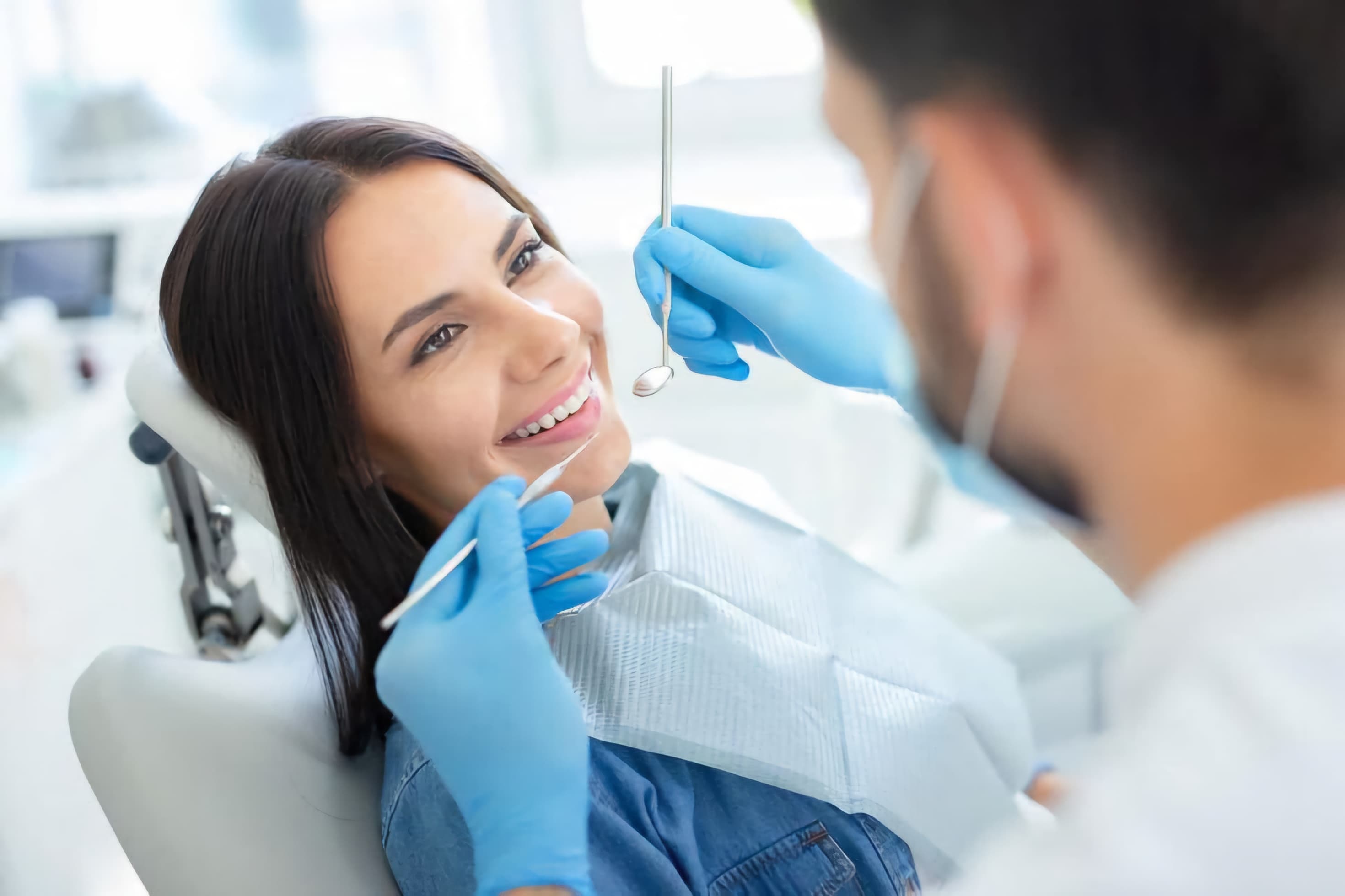 Dentist examining a patient's teeth with a mirror during a routine checkup