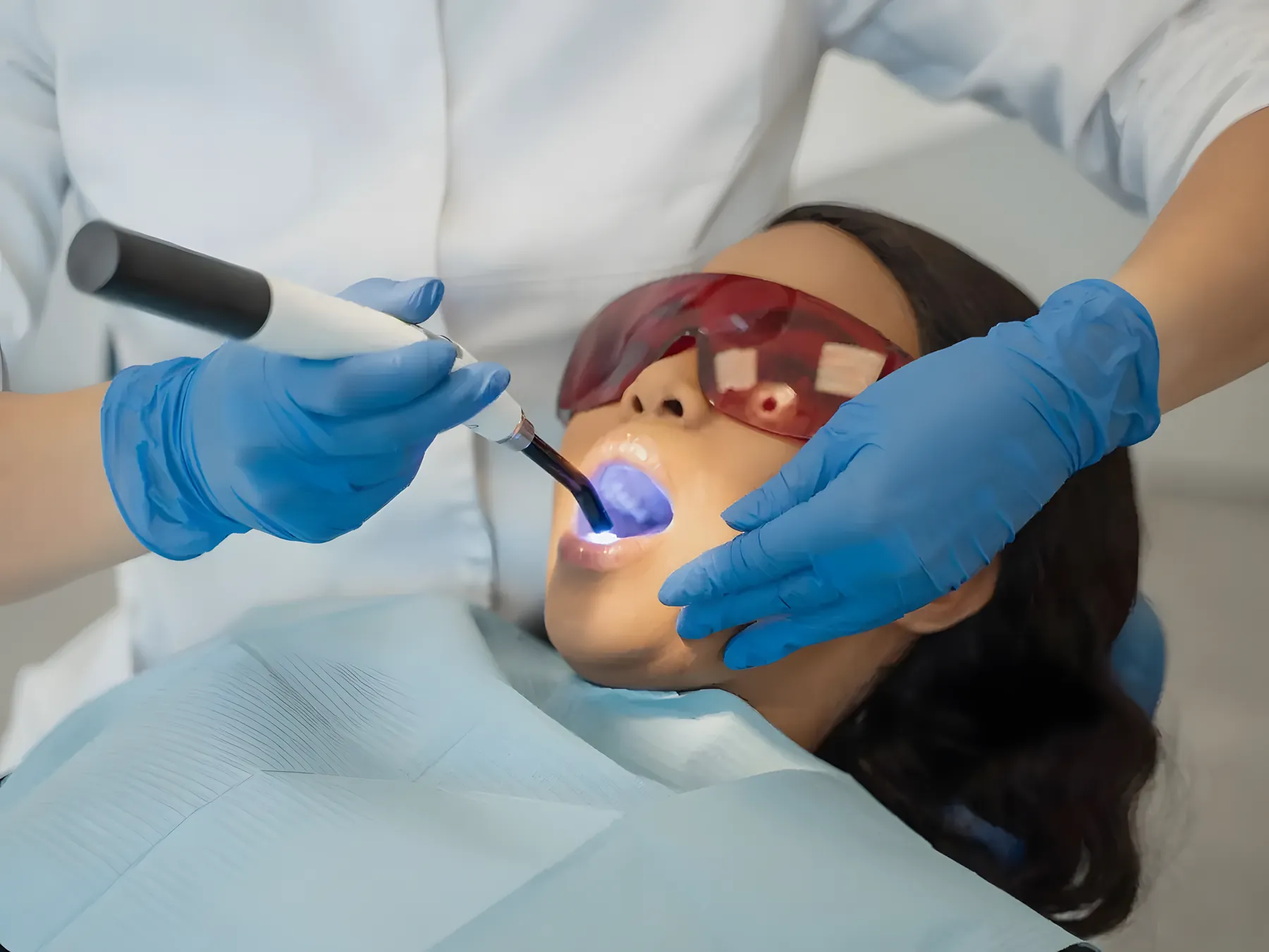 Dentist light-curing a tooth-coloured filling to restore a tooth